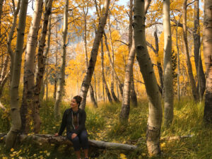 Valerie Cantella, memoir book coach, in a forest of fall leaves at ValerieCantella.com